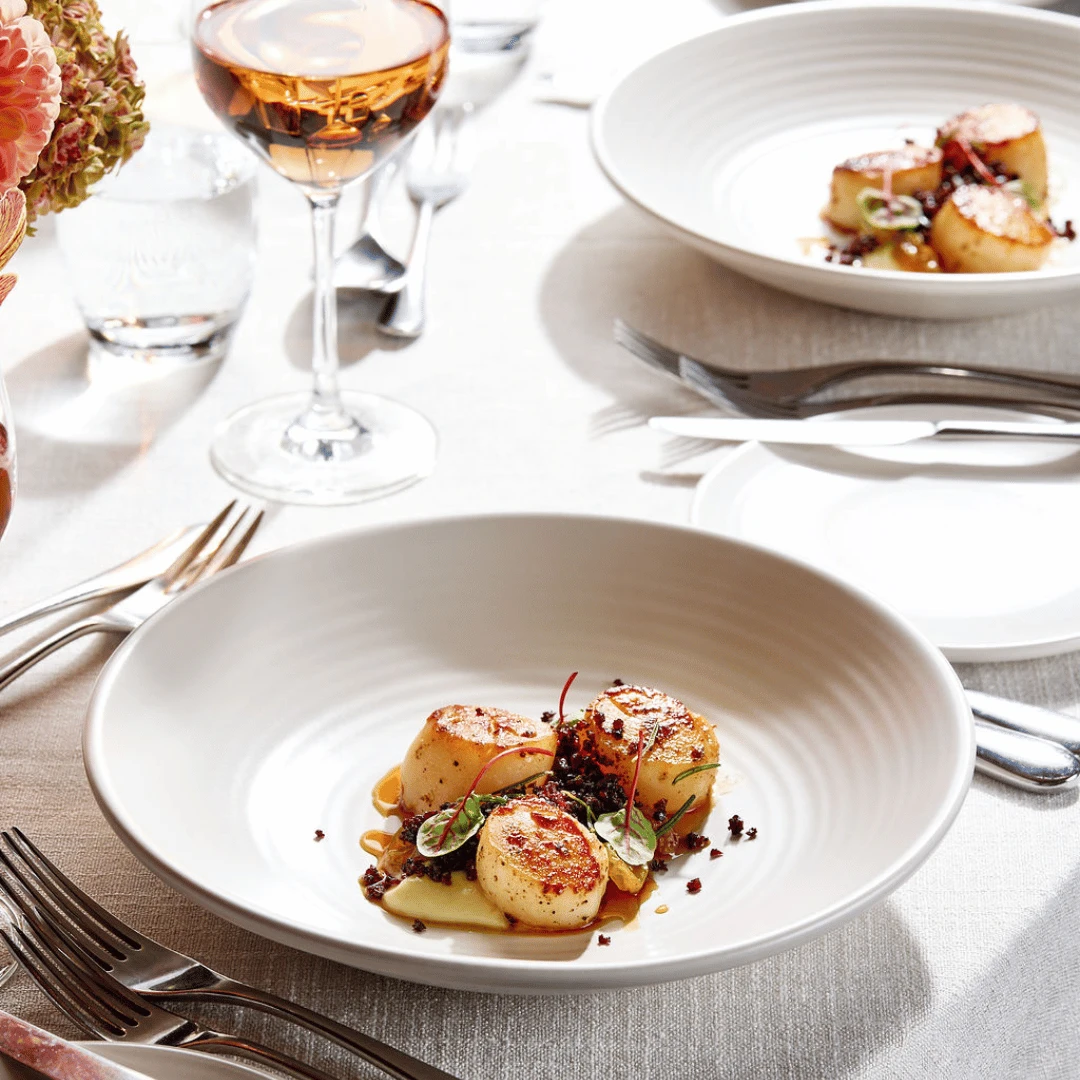 Seared scallops, caramelised celeriac, macerated golden raisins, morcilla, vanilla and cocoa fruit vinaigrette